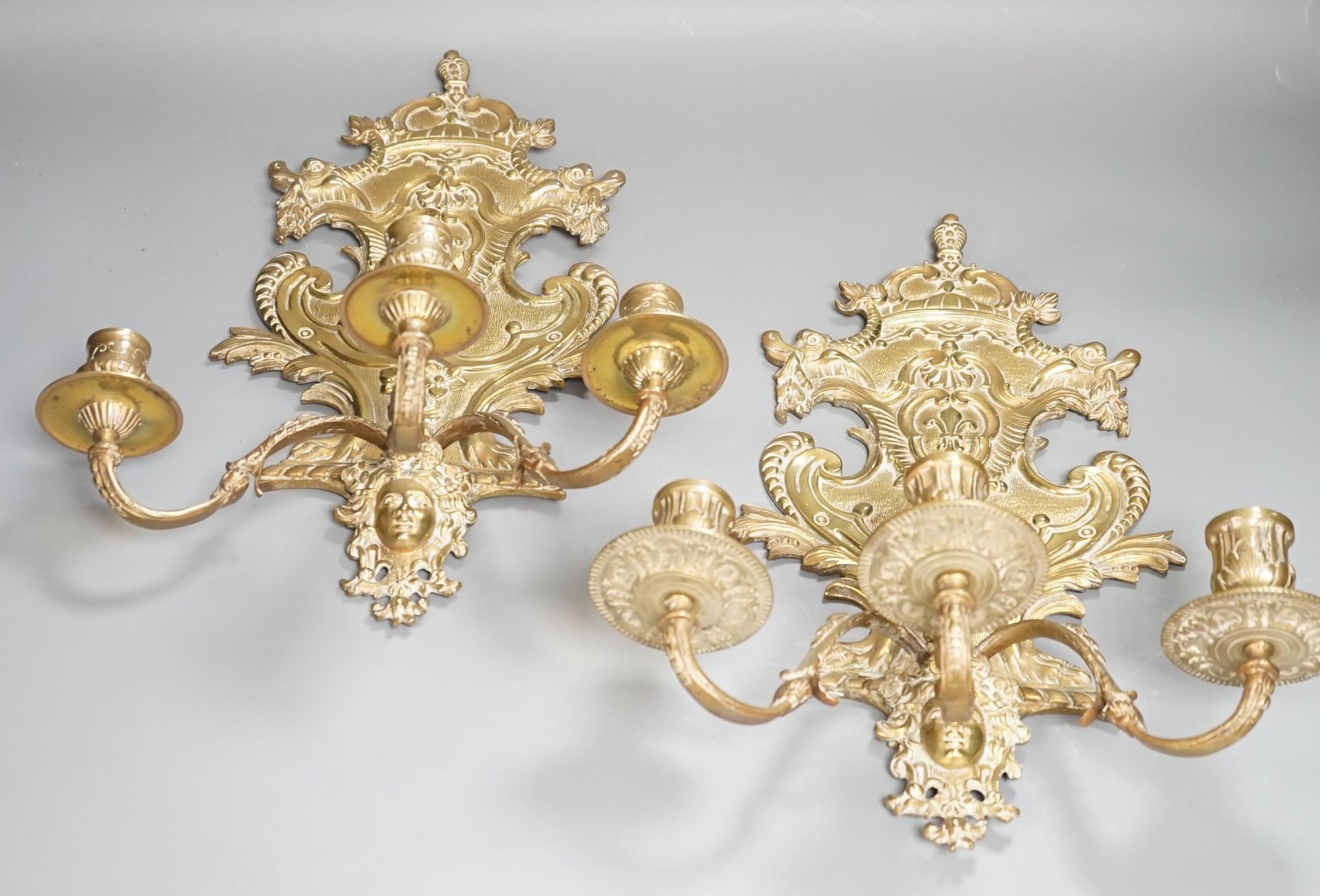 A pair of French ornate brass three branch wall sconces, 37 cms high